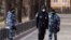 FILE - Police officers wearing face masks patrol at Patriarch Ponds in Moscow, Russia, April 22, 2020.