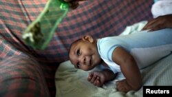 Jackeline, 26 ans, utilise une bouteille verte pour stimuler son fils Daniel, 4 mois, né avec une microcéphalie à Olinda, près de Recife, au Brésil, le 11 février 2016.