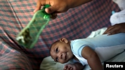 Jackeline, de 26 años, usa una botella verde para estimular a su hijo Daniel, de cuatro meses, quien nació con microcefalia, en Olinda, cerca de Recife, Brasil.
