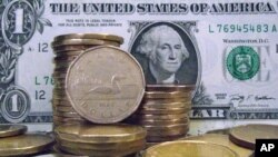 Canadian dollar coins, also known as "loonies," are posed with U.S dollar bills Tuesday, April 6, 2010, in Montreal.