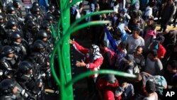 Migrants plead with Mexican National Guardsmen at the border crossing between Guatemala and Mexico in Tecun Uman, Guatemala, Jan. 18, 2020. 