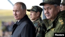 Russian President Vladimir Putin, Defense Minister Sergei Shoigu and Chinese Defense Minister Wei Fenghe watch the military parade during Vostok-2018 (East-2018) war games at Tsugol military training ground in Zabaikalsky region, Russia, Sept. 13, 2018.