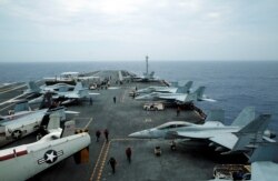 FILE - Hornet fighter jets and E-2D Hawkeye plane are seen on the aircraft carrier John C. Stennis during joint military exercise called Malabar, with the US, Japan and India participating, off the island of Okinawa, June 15, 2016.