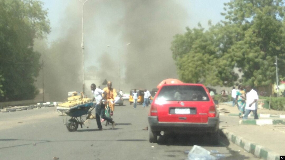 Warga di Maiduguri berlarian saat sebuah bom mobil meledak di daerah yang ramai hari Selasa (14/1). 