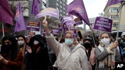 Women hold placards defending the Istanbul Convention during a protest rally in Ankara, Turkey, March 20, 2021.