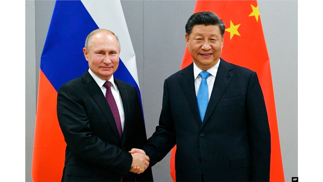 Presiden Rusia Vladimir Putin, kiri, dan Presiden China Xi Jinping berjabat tangan sebelum melakukan pembicaraan di sela-sela KTT BRICS edisi ke-11, di Brasilia, Brazil pada 12 November 2019. (Foto: via AP)