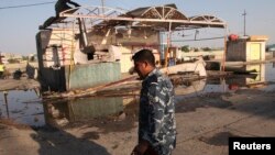 A policeman walks near the site of a bomb attack in Amara, 300 kilometers southeast of Baghdad, Iraq, Aug. 21, 2013.