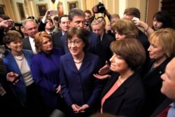 Sen. Heidi Heitkamp (2nd from left) with Sen. Susan Collins (center), Sen. Amy Klobuchar (2nd from right), and other lawmakers at the Capitol in Washington, Jan. 22, 2018.