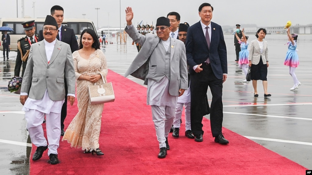 2023年9月23日尼泊尔总理普沙帕·卡马尔·达哈尔“普拉昌达”(中)抵达中国杭州出席第十九届亚运会开幕式时挥手致意(photo:VOA)