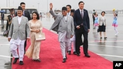 2023年9月23日尼泊尔总理普沙帕·卡马尔·达哈尔“普拉昌达”(中)抵达中国杭州出席第十九届亚运会开幕式时挥手致意