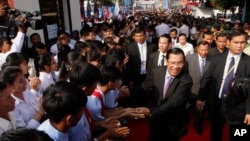 Cambodian Prime Minister and President of Cambodian People's Party Hun Sen, second right in front, greets his supporters after an event by his ruling party to mark the 37th anniversary of the 1979 downfall of the Khmer Rouge regime at the party headquarters in Phnom Penh, Cambodia, Thursday, Jan. 7, 2016. (AP Photo/Heng Sinith)