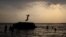 FILE - A boy prepares to jump off a rock into the waters of the Osman Sagar Lake near the southern Indian city of Hyderabad, May 29, 2011.