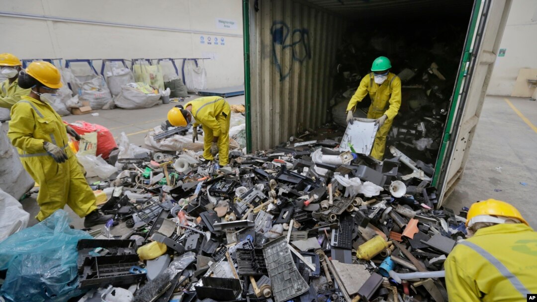 ARCHIVO: Trabajadores descargan y clasifican la basura electrónica de un contenedor, recolectada en un basurero de Nairobi y trasladada a la instalación de Cumplimiento de Reciclaje de África Oriental en Machakos, cerca de Nairobi, Kenia, el 18 de agosto de 2014.