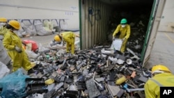ARCHIVO: Trabajadores descargan y clasifican la basura electrónica de un contenedor, recolectada en un basurero de Nairobi y trasladada a la instalación de Cumplimiento de Reciclaje de África Oriental en Machakos, cerca de Nairobi, Kenia, el 18 de agosto de 2014.