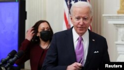 U.S. President Joe Biden speaks about his administration's plans to fight the coronavirus disease (COVID-19) pandemic as Vice President Kamala Harris listens during a COVID-19 response event at the White House in Washington, Jan. 21, 2021.