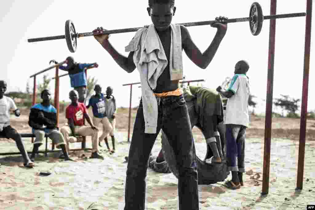 Un jeune enfant de la rue, également appelé &quot;Talibe&quot;, joue à soulever des poids en zone de quarantaine, dans un refuge pour enfants de rue nouvellement arrivés à l&#39;extérieur de Dakar, le 10 avril 2020.