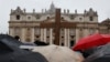 Pilgrims hold a cross in front of St. Peter's Basilica while cardinals meet in the Sistine Chapel to elect a new pope, at the Vatican, March 13, 2013. 