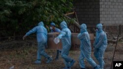 Indian paramilitary soldiers carry the body of a colleague who died of COVID-19, for cremation at a crematorium in Srinagar, Indian controlled Kashmir, July 18, 2020.