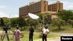 A television crew films outside a military hospital where former South African president Nelson Mandela is hospitalized in Pretoria, December 9, 2012. 