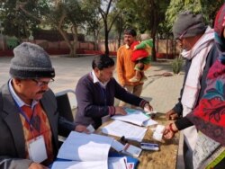 Voters in a low income area in New Delhi search for their names on the electoral rolls, New Delhi, India, Feb. 8, 2010. (A. Pasricha/VOA)