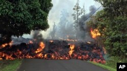 Photo provided by the U.S. Geological Survey shows a lava flow moving across Makamae Street in the Leilani Estates subdivision near Pahoa on the island of Hawaii, May 6, 2018.