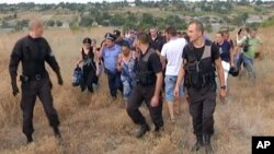 Beberapa polisi Ukraina mengawal warga etnis Gipsi yang mengungsi dari desa Loshchynivka, Odessa, setelah warga setempat menyerang dan menjarah rumah mereka (foto: ilustrasi). 