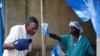 Un agent de santé mesure la température d'un homme entrant dans le centre de traitement Ebola à Beni, en République démocratique du Congo, le 1er avril 2019. 