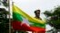 FILE - The Myanmar national flag flies in front of a statue of Gen. Aung San during a ceremony marking the 70th anniversary of his 1947 assassination in Naypyitaw, Myanmar, Wednesday, July 19, 2017. (AP Photo/Aung Shine Oo)