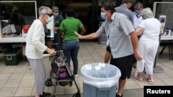 Para pengunjung antre pemeriksaan kesehataan sebelum memasuki RS Jackson Memorial di Miami, Florida, setelah pemerintah setempat melonggarkan pembatasan terkait pandemi virus corona (COVID-19), 18 Juni 2020. (Foto: Reuters)