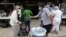 Cư dân chờ kiểm tra sức khỏe trước khi vào Bệnh viện Jackson Memorial vào lúc Quận Miami-Dade, Florida nới lỏng một số biện pháp đóng cửa (ảnh chụp ngày 18/6/2020)