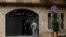 A private security guard speaks with a policeman at the residence of former Nissan chairman Carlos Ghosn, in Beirut, Lebanon, Dec. 31, 2019.