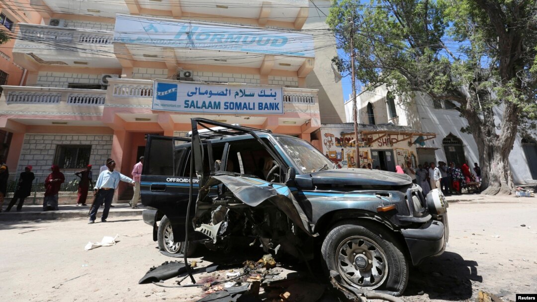 Warga mengamati sisa-sisa mobil milik anggota parlemen Somalia Isaak Mohamed Rinoco, yang tewas akibat bom yang dipasang di mobilnya oleh militan Islam di distrik Hamaerweyne, Mogadishu (21/4). Al-Shabab mengaku bertanggung jawab atas tewasnya seorang lagi anggota parlemen Abdiaziz Isaq Mursal, Selasa (22/4) di Madina, Mogadishu.