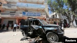 Warga mengamati sisa-sisa mobil milik anggota parlemen Somalia Isaak Mohamed Rinoco, yang tewas akibat bom yang dipasang di mobilnya oleh militan Islam di distrik Hamaerweyne, Mogadishu (21/4). Al-Shabab mengaku bertanggung jawab atas tewasnya seorang lagi anggota parlemen Abdiaziz Isaq Mursal, Selasa (22/4) di Madina, Mogadishu.