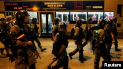 Riot police pursue demonstrators during clashes in Hong Kong, Aug. 24, 2019.