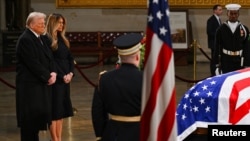 El presidente electo Donald Trump y su esposa, Melania Trump, frente al féretro del expresidente Jimmy Carter durante su funeral en el Capitolio federal, el miércoles 8 de enero de 2025, en Washington.