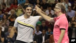 Roger Federer, of Switzerland, left, celebrates with partner Bill Gates as they play an exhibition tennis match against Jack Sock and Savannah Guthrie in San Jose, Calif., Monday, March 5, 2018. 