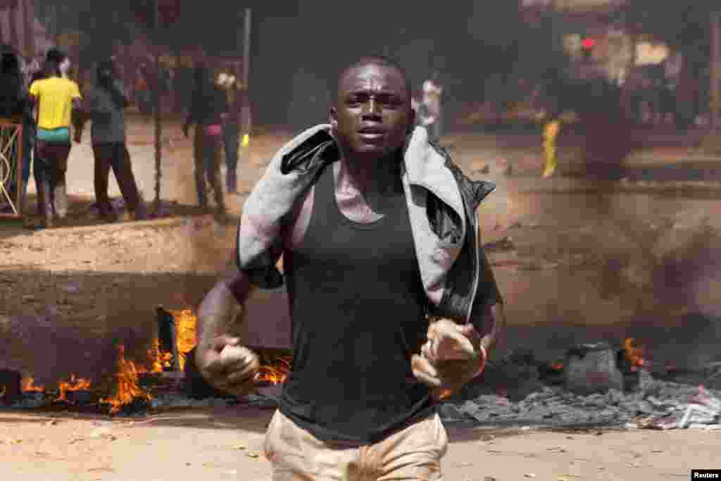 Un manifestant &nbsp;a des pierres dans ses mains sur une route barricadée à Ouagadougou, capitale de Burkina Faso, le 28 octobre 2014. REUTERS/Joe Penney 