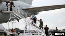 Venezuelan descend from a Brazilian Air Force plane after arriving at the Eduardo Gomes International Airport in Manaus, Brazil, May 4, 2018. 