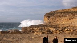 Tourists walk away after viewing the site where the natural structure known as the Azure Window collapsed, after the Maltese islands were hit by rough seas and stormy weather, at Dwejra on the island of Gozo, Malta, March 8, 2017. 
