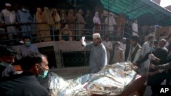 27일 파키스탄 페샤와르의 이슬람 학교에서 폭탄이 폭발한 가운데 부상자가 병원으로 옮겨지고 있다. 