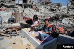 Siswa Palestina menghadiri kelas di tenda yang didirikan di atas reruntuhan rumah guru Israa Abu Mustafa di Khan Younis di Jalur Gaza selatan, 4 September 2024. (Foto: Reuters)