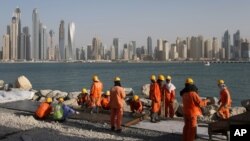 FILE - Laborers work at a construction site at the Palm Jumeirah, in Dubai, United Arab Emirates.