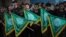 FILE - Palestinian youths hold Hamas movement flags during a rally near the Rafah border between southern Gaza Strip and Egypt on February 5, 2015.