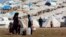 Syrian refugees filling their buckets at Atmeh refugee camp, in the northern Syrian province of Idlib, Syria, Apr. 5, 2013