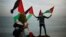 Palestinians wave national flags during a protest against the blockade on Gaza, at the seaport of Gaza City Dec. 2, 2013.