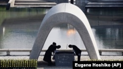 FILE - Kazumi Matsui, right, mayor of Hiroshima bows, at Hiroshima Memorial Cenotaph in Hiroshima, western Japan, Aug. 6, 2015. The Nobel Peace Prize has been awarded to a Japanese organization of atomic bomb survivors. (AP Photo/Eugene Hoshiko, File)