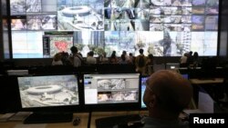 A policeman observes a screen displaying the Maracana stadium during a media tour at the security center for the 2014 soccer World Cup in Rio de Janeiro, Jan. 22, 2014.