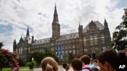 FILE - Prospective students tour Georgetown University's campus July 10, 2013, in Washington. 