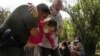 Un agente de la Patrulla Fronteriza de EE. UU. ayuda a una anciana migrante venezolana que busca asilo después de que la mujer cruzó el río Grande hacia los Estados Unidos desde México en Del Rio, Texas, el 26 de mayo de 2021.