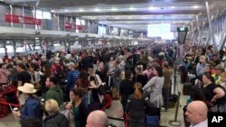 People crowd a terminal at Sydney's domestic airport as passengers are subjected to increased security, in Sydney, Australia, Monday, July 31, 2017. 